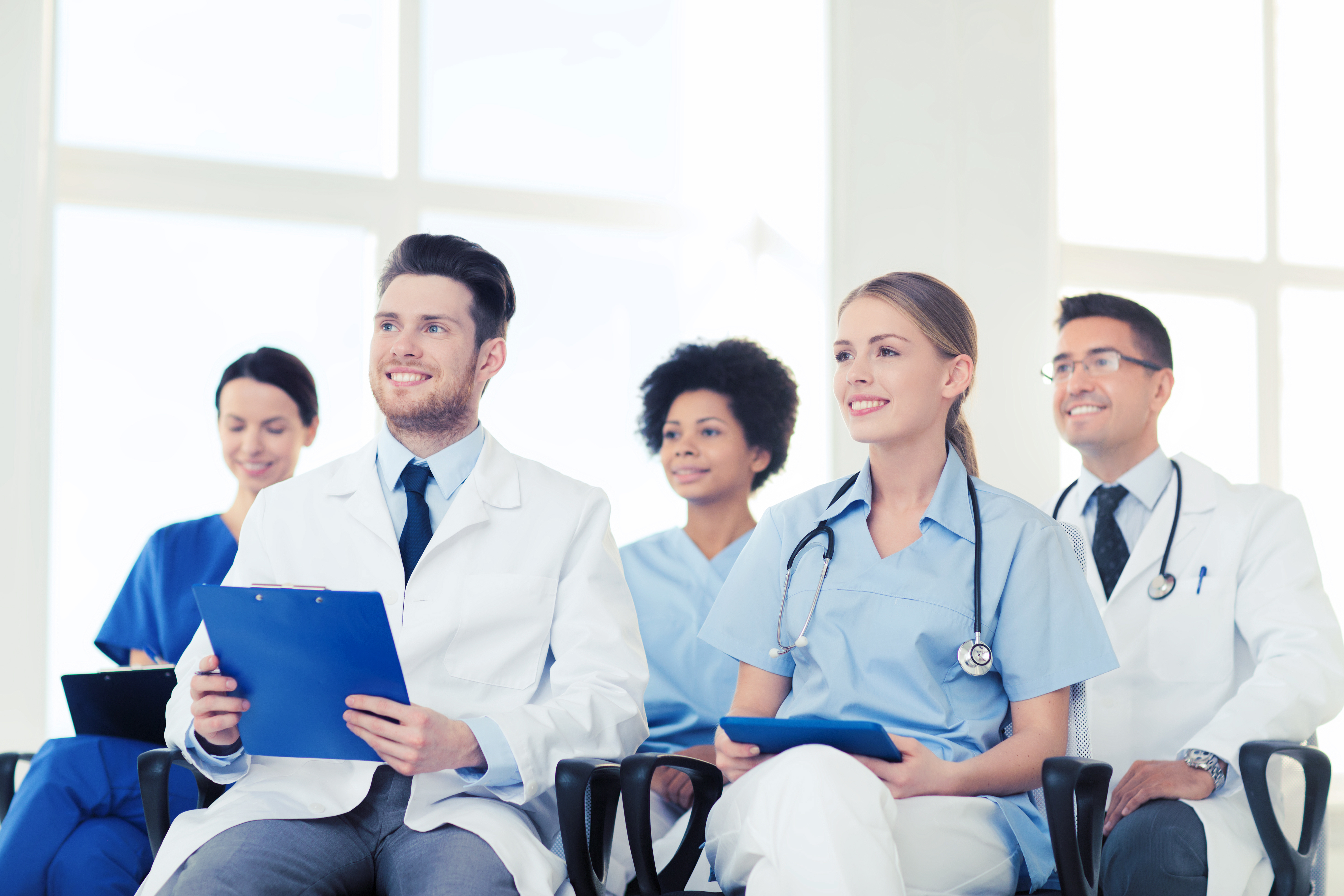 group of happy doctors on seminar in lecture hall at hospital